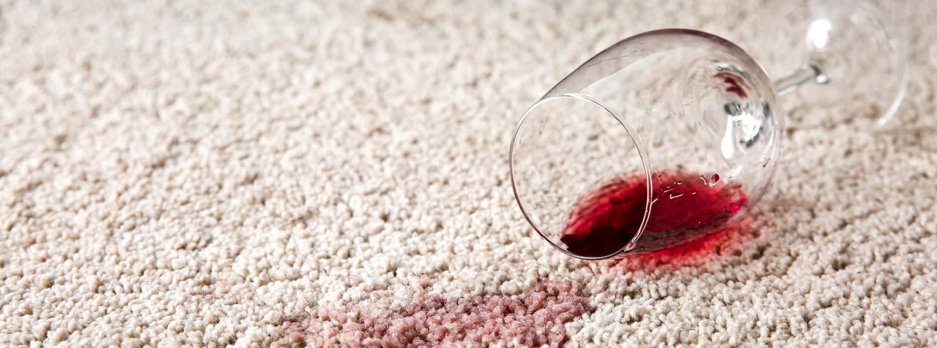 This is a photo of Ruislip Carpet Cleaning Solutions red wine which has been spilt on a cream carpet. The glass is on its side.